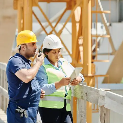 Construction workers discussing plans on-site.