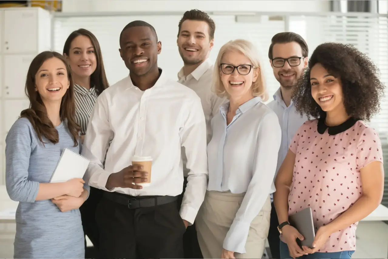 Group of smiling colleagues in office setting.