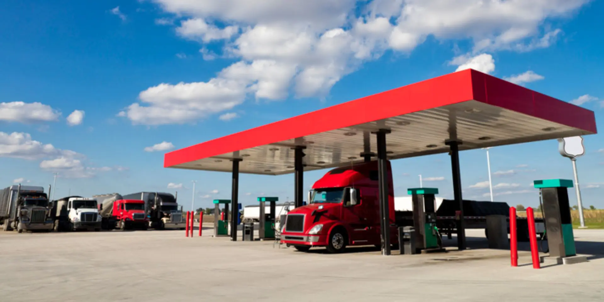 Red semi truck at highway fueling station
