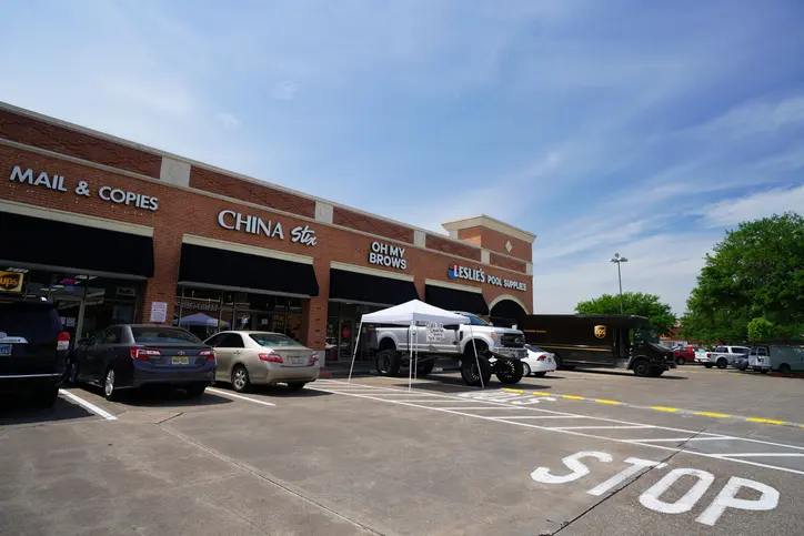 Strip mall parking lot with tent and vehicles