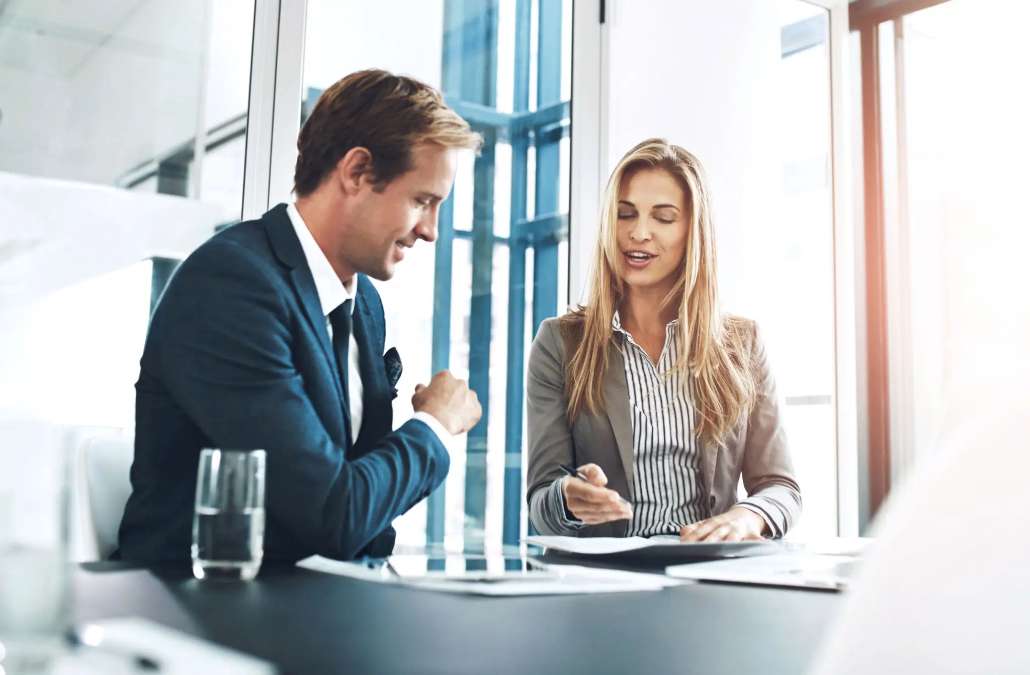 Two professionals discussing in an office setting.